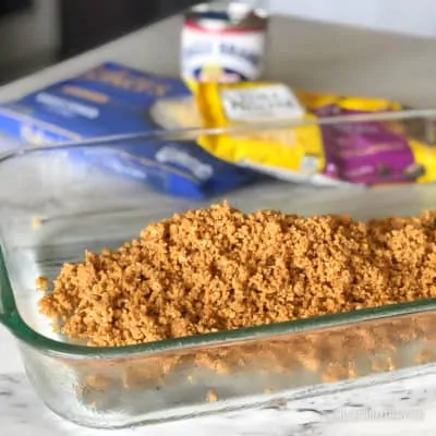 Crushed graham crackers in a glass baking pan