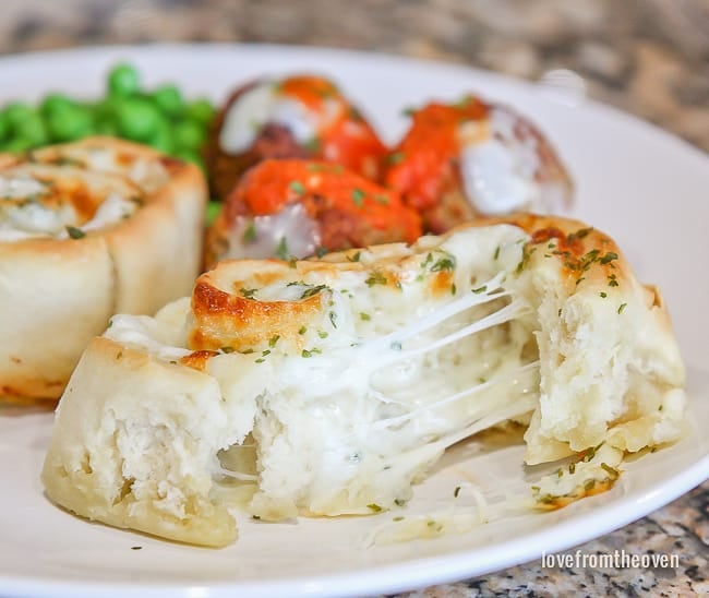 A garlic roll torn open with melty cheese