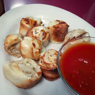 A plate of garlic rolls and marinara sauce from John\'s NYC