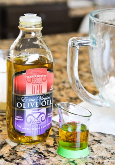 A bottle and measuring cup full of olive oil