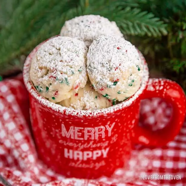 Red mug filled with snowball cookies