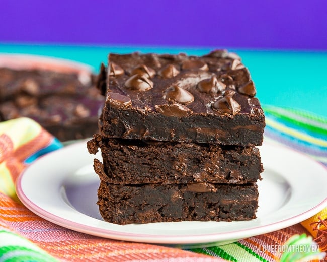 Three black bean brownies stacked on a plate