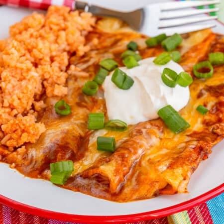 A plate with cheese enchiladas and mexican rice