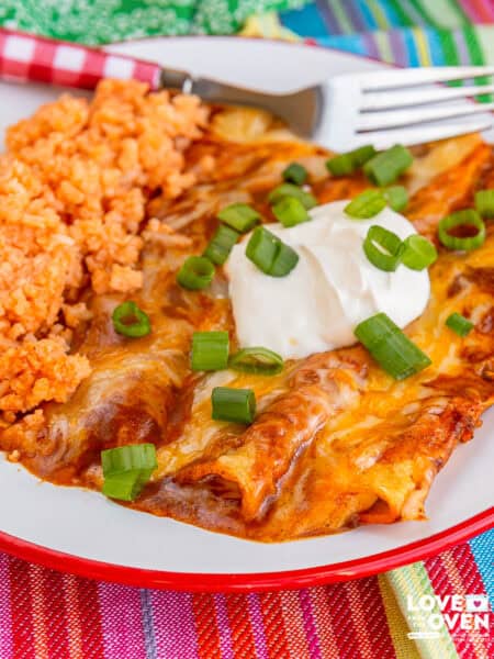 A plate with cheese enchiladas and mexican rice