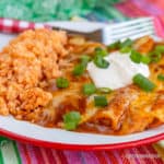 Cheese enchiladas with green onions and sour cream with rice