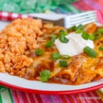 Cheese enchiladas with green onions and sour cream with rice