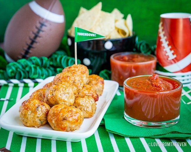 Plate of chicken parm meatballs next to bowl of marinara sauce