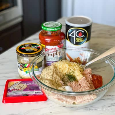 Ingredients for chicken parm meatballs in their containers and combined in a bowl