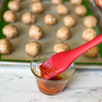 Chicken parm meatballs on baking sheet with sauce