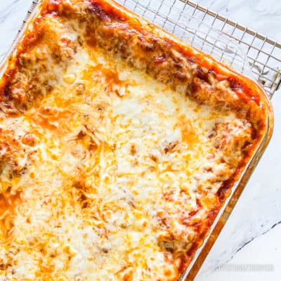 Overhead shot of a lasagna in a glass pan sitting on a wire cooling rack