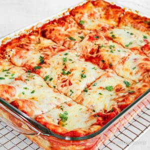 Cheese lasagna cut into square servings in glass baking pan
