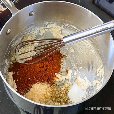 Raw ingredients for enchilada sauce in stainless steel pot