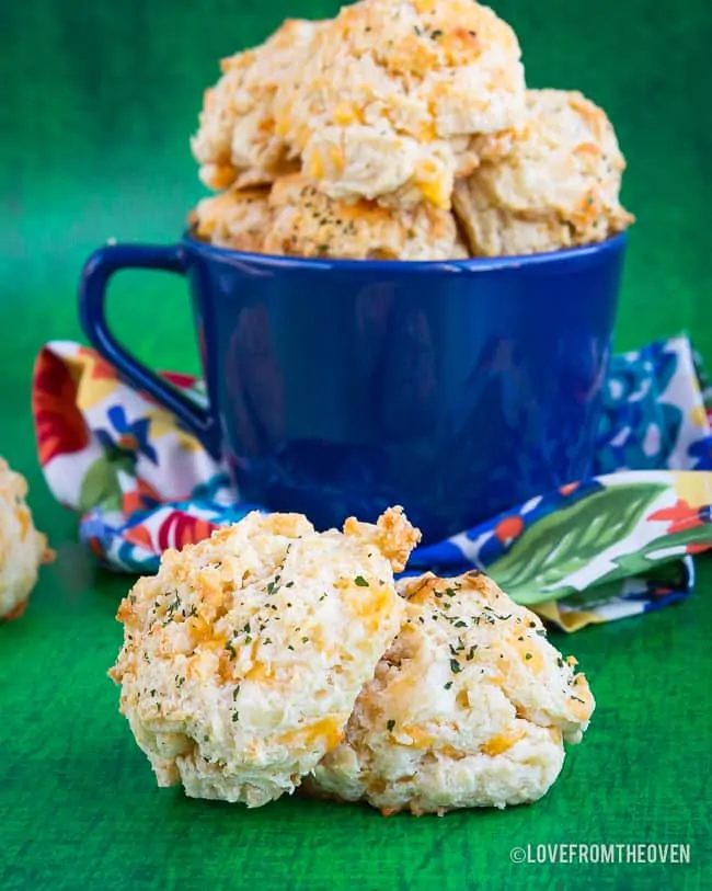 Cheddar bay biscuits in a cup and on a table