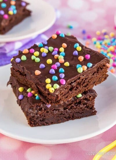 Two brownies with rainbow sprinkles on a plate