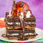 Brownies on a plate topped with ice cream and chocolate sauce