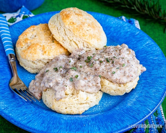 Food on a blue plate, with Gravy and Biscuit