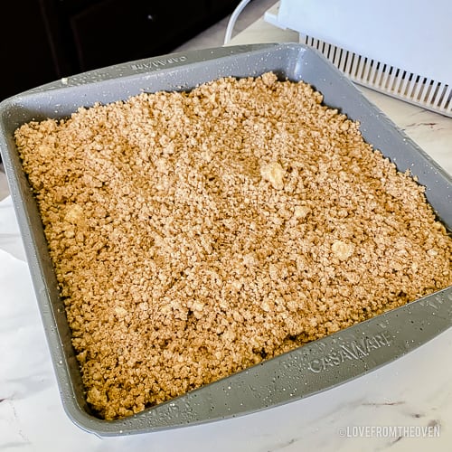 Pan of blueberry buckle with crumb topping about to go into the oven