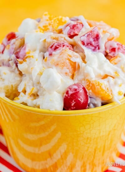 Bowl of ambrosia salad with a yellow background