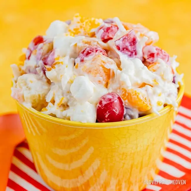 Bowl of ambrosia salad with a yellow background