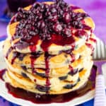 Stack of blueberry pancakes with blueberry topping on the top