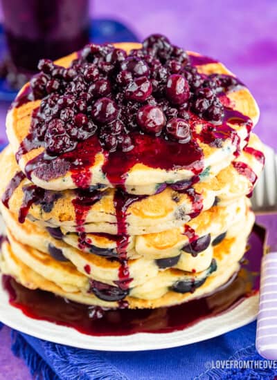 Stack of blueberry pancakes with blueberry topping on the top