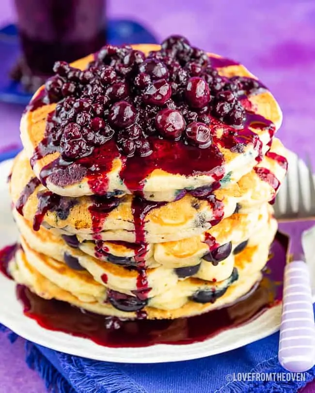 Stack of blueberry pancakes with blueberry topping on the top