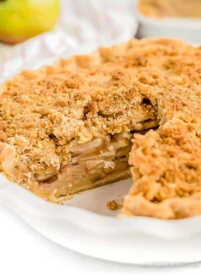 dutch apple pie in a pie dish with a slice taken out