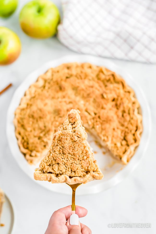 A slice of Dutch apple pie cut out of a pie