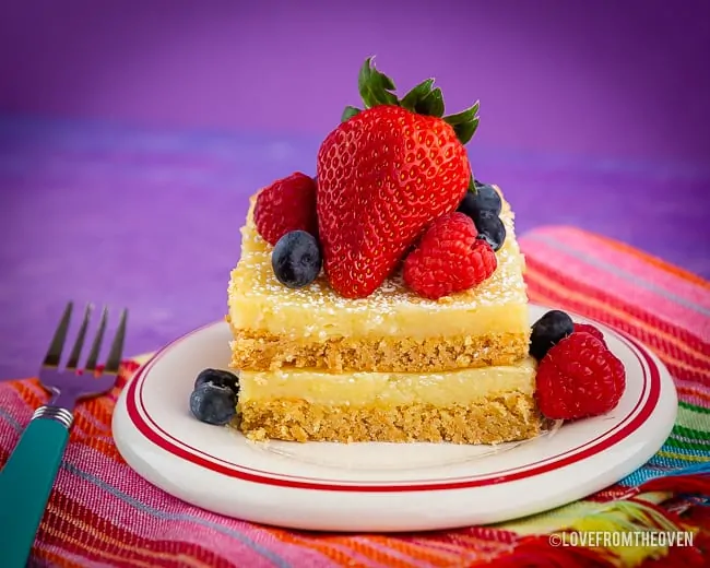 Ooey Gooey Butter Cake on a plate topped with berries