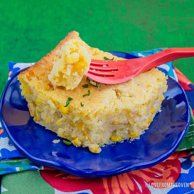 Slice of Jiffy Corn Casserole on a blue plate with a red fork