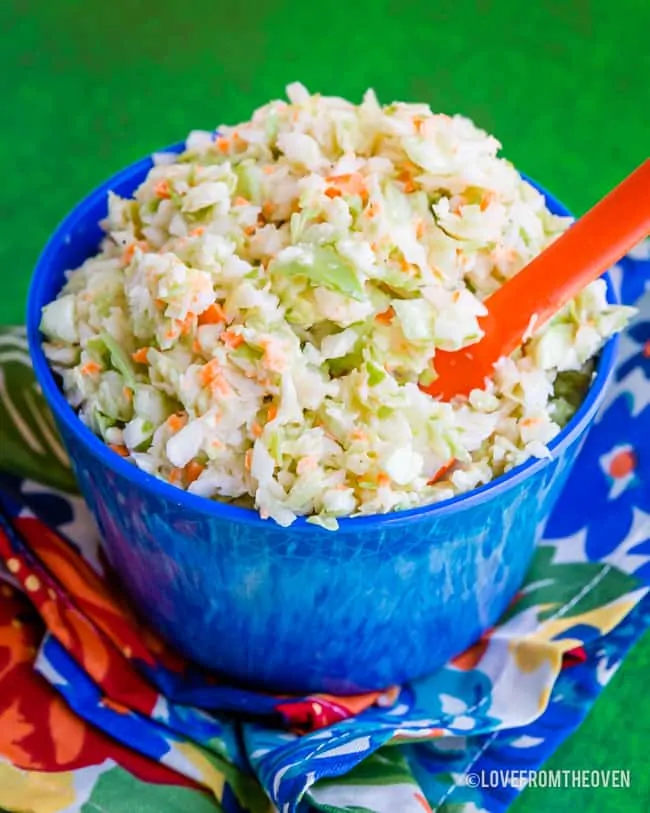 Blue bowl holding KFC Coleslaw Copycat Recipe with a green background