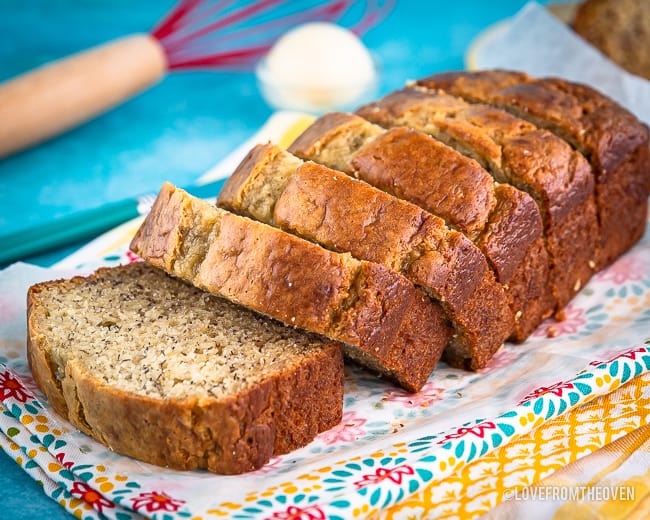 Sliced loaf of banana bread on a blue background and print dishtowel