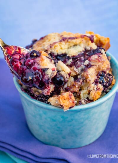 Serving of blueberry dump cake in a blue ramekin