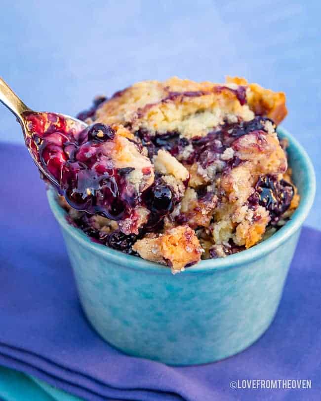 Serving of blueberry dump cake in a blue ramekin