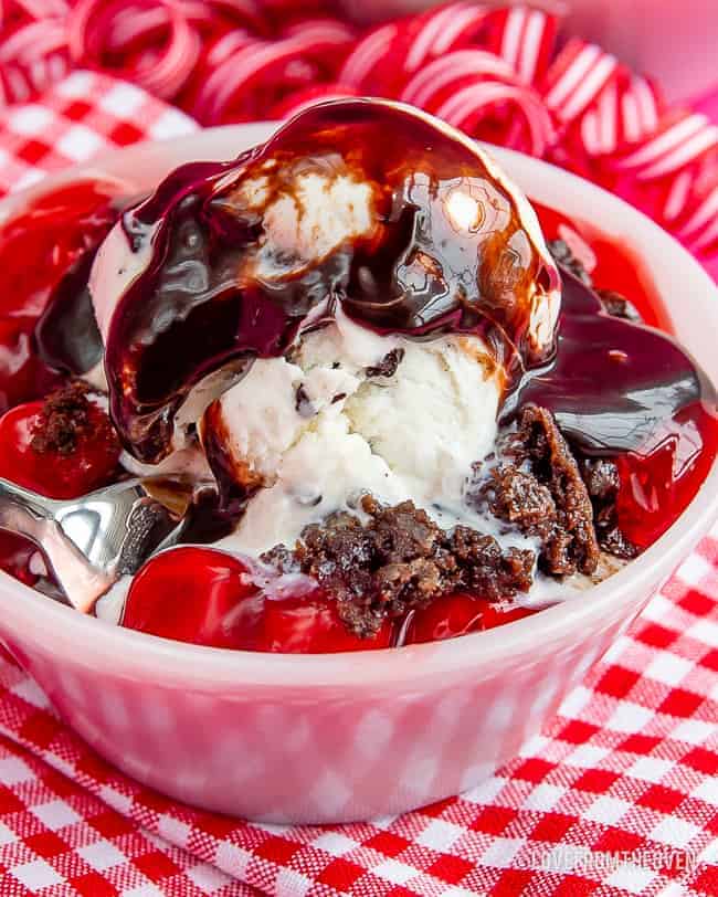 A bowl with chocolate cake, ice cream and cherries