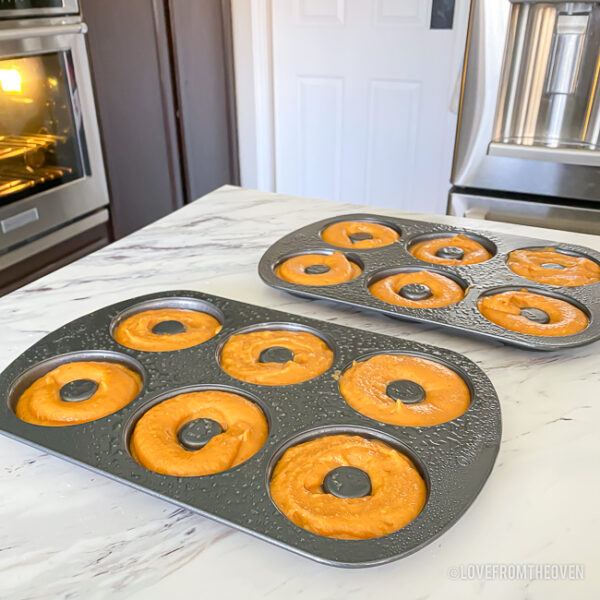 Pumpkin donut batter in pans