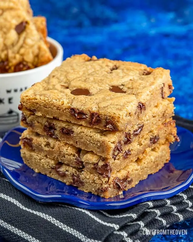 Brown butter blondies stacked on a blue plate