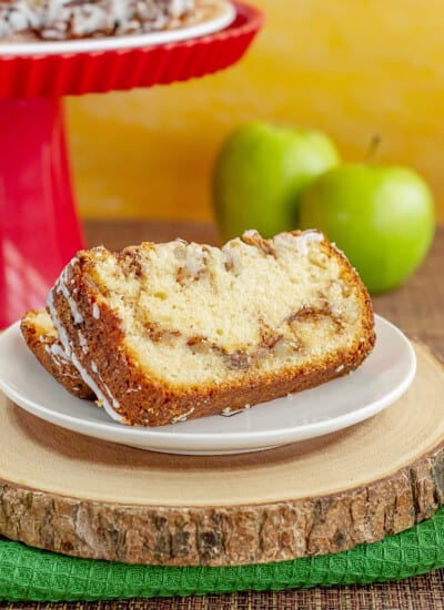 apple bread with apples and a red cake stand behind it