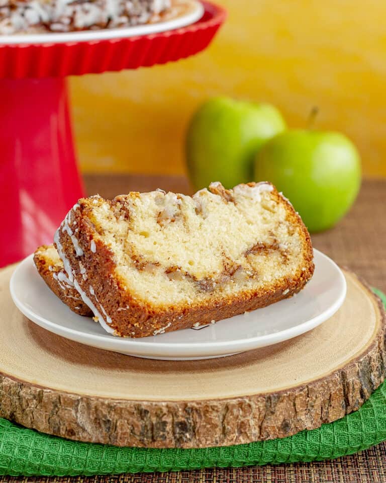apple bread with apples and a red cake stand behind it