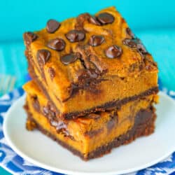 Two pumpkin brownies stacked on a plate.