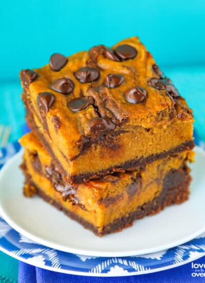 Two pumpkin brownies stacked on a plate.