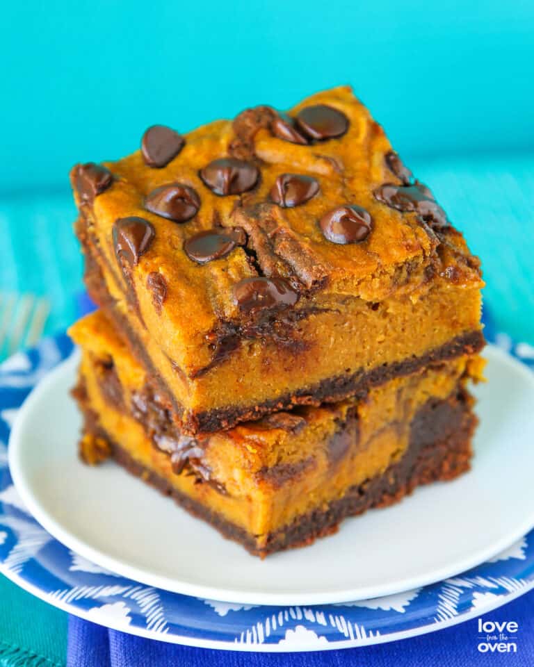 Two pumpkin brownies stacked on a plate.
