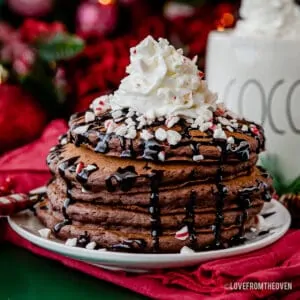 A stack of hot chocolate pancakes topped with whipped cream