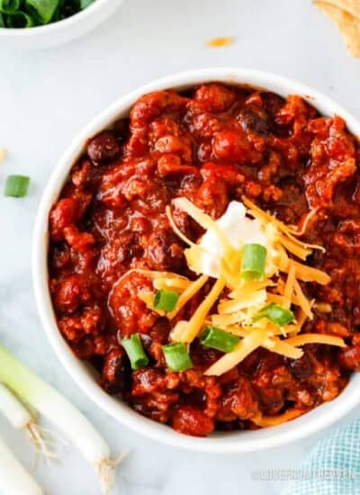 bowl of crockpot beef chili topped with sour cream and cheese