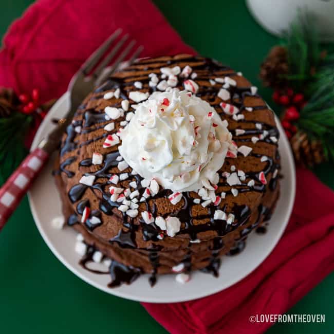 A stack of hot chocolate pancakes topped with whipped cream