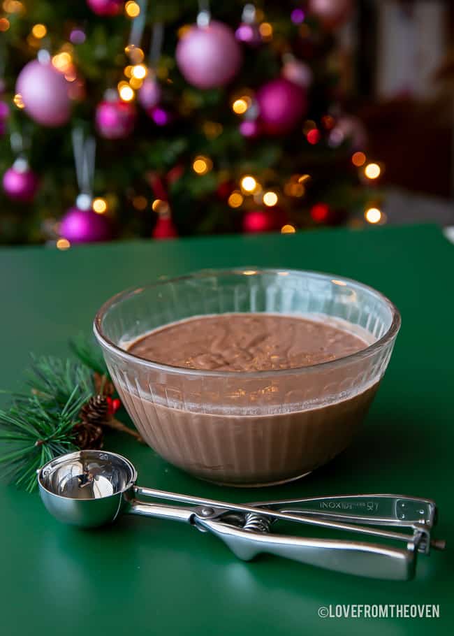 A bowl of chocolate pancake batter on a green background