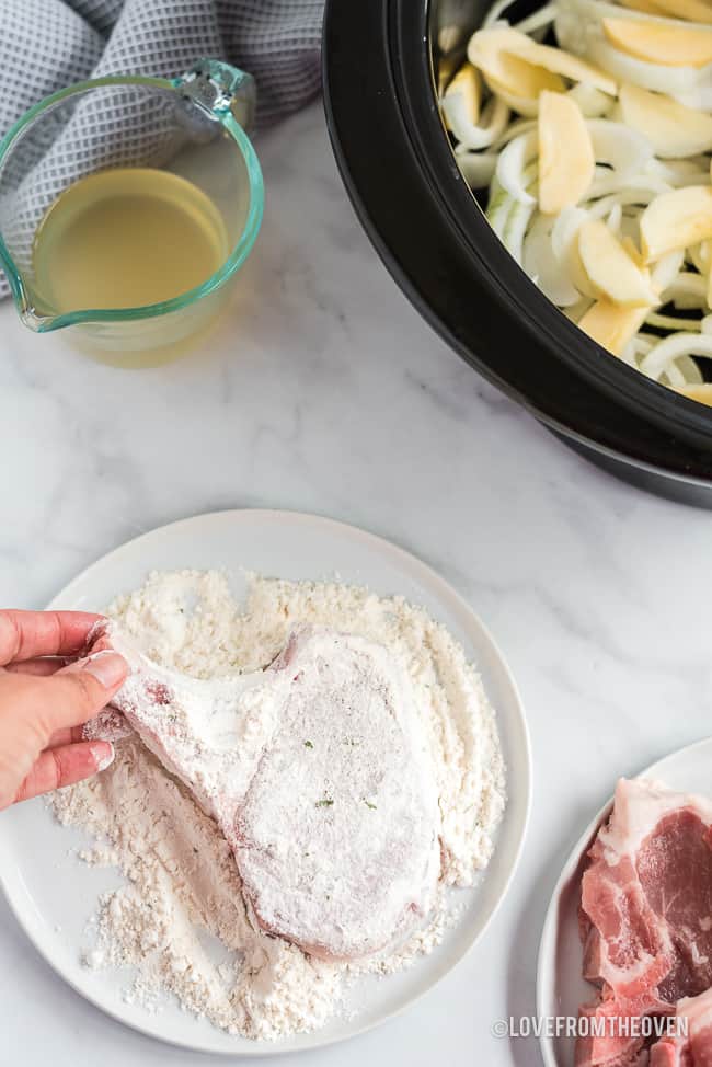 Pork chops being prepared to cook in a crock pot