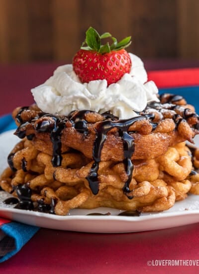 a stack of funnel cakes topped with whipped cream