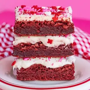 stack of red velvet brownies with frosting and pink and red sprinkles
