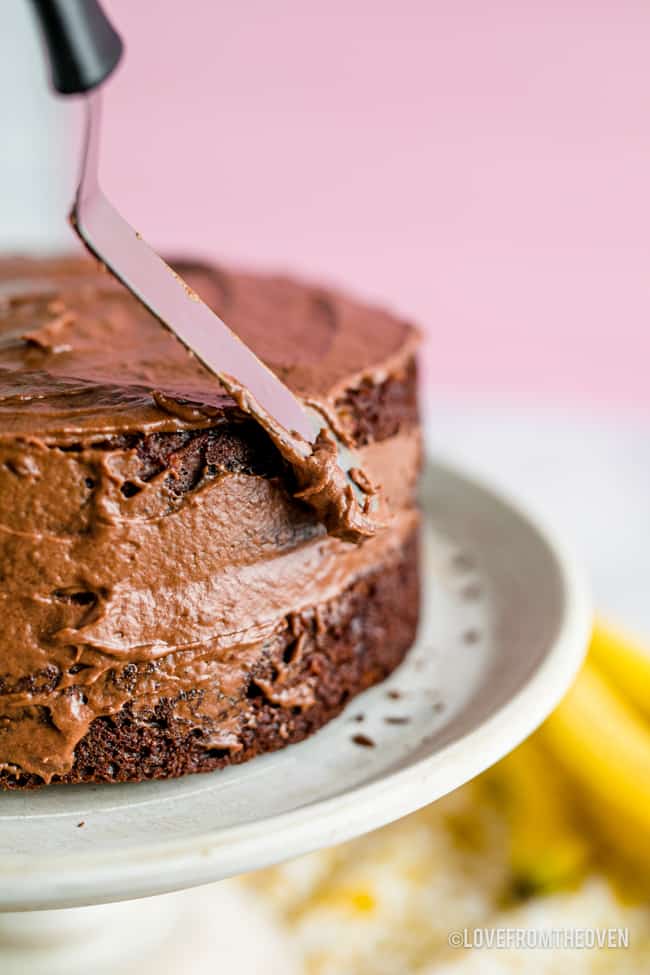 a chocolate cake being frosted